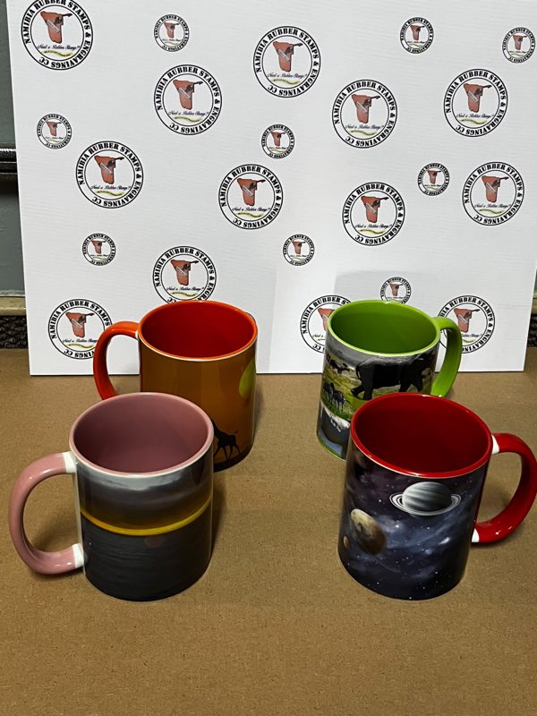 Four ceramic coffee mugs printed with wildlife, landscape and space designs