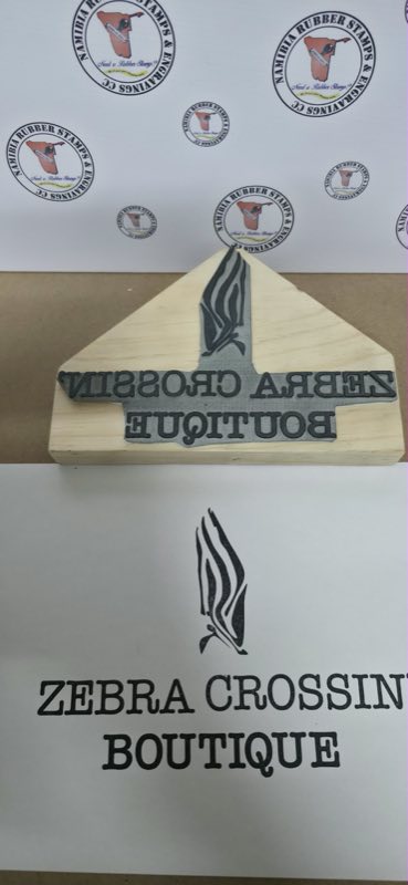 A shaped wooden hand stamp beside the impression it makes