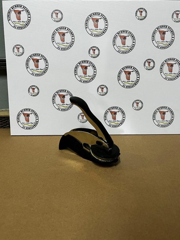 Hand-held desk embosser with a black and chrome body