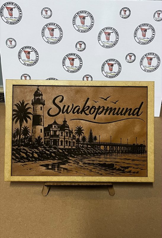 Laser-engraved leather panel showing the Swakopmund lighthouse, Hohenzollern building and jetty, framed in wood