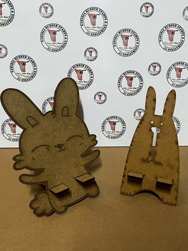 Two laser-cut wooden phone stands shaped like rabbits